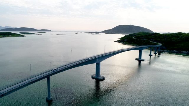 Fly over drone shot of fjord bridge with car traffic crossing over bridge towards Sommaroy island