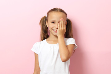 little cute cheerful girl passes an eye test in the office of an ophthalmologist