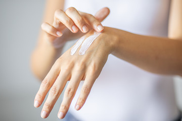 Woman applying hand cream - stock photo