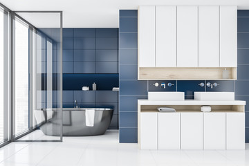Blue tile bathroom interior, tub and sinks