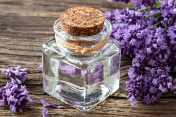 A bottle of lavender essential oil with lavender twigs