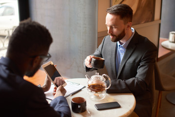 Two businessmen having a coffee break in the cafe.
