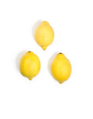 Three yellow fresh lemons isolated on white background. Vertical image.