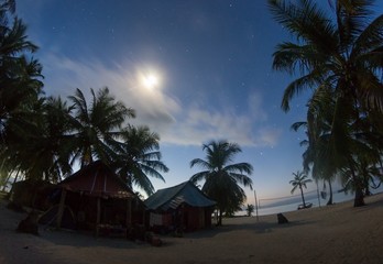 Sunrise on an island of San Blas in Panama located in the Caribbean Sea where you can see palm trees, cabins and the beach. Vacation and relaxation concept