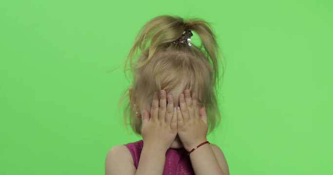 Child portrait in purple dress. Hides her face with hands and sculps. Chroma Key