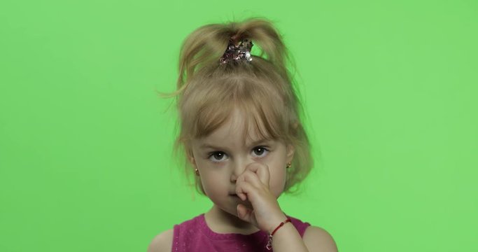 Child portrait in purple dress. Girl nose picking. Chroma Key
