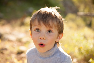 beautiful portrait of a baby boy smiling in nature for a walk