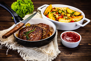 Grilled steaks, baked potatoes and vegetables