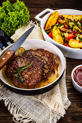 Grilled steaks, baked potatoes and vegetables