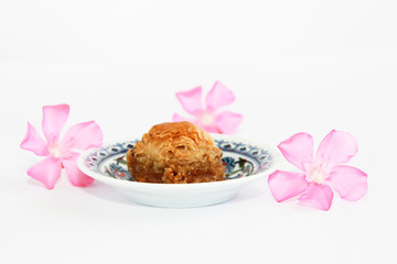 traditional Turkish sweetness baklava on plate with patterns and decor of pink flowers