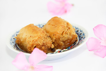traditional Turkish sweetness baklava on plate with patterns and decor of pink flowers