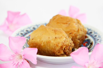 traditional Turkish sweetness baklava on plate with patterns and decor of pink flowers