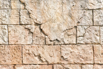 Old gray wall of rectangular stone blocks with remnants of plaster. Abstract background