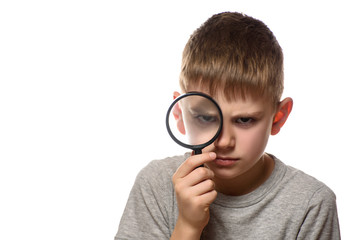 Serious boy with a magnifying glass in his hands. Little explorer. White background
