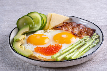 Close up view of the ketogenic diet breakfast on the white plate on linen fabric.