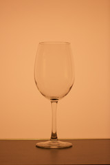 Wine glass on a long stem. In back yellow color.
