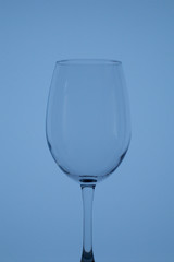 Wine glass on a long stem. In back blue color.