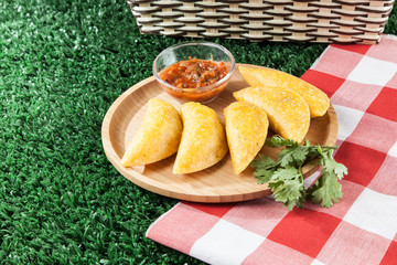 Colombian empanada with spicy sauce.