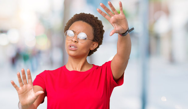 Beautiful young african american woman wearing glasses over isolated background Smiling doing frame using hands palms and fingers, camera perspective