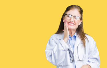 Middle age mature doctor woman wearing medical coat over isolated background touching mouth with hand with painful expression because of toothache or dental illness on teeth. Dentist concept.