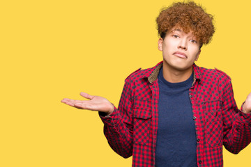 Young handsome student man with afro hair wearing a jacket clueless and confused expression with...