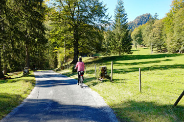 Frau auf Fahrrad im Wald im Herbst bei Füssen