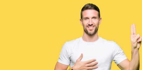 Handsome man wearing casual white t-shirt Swearing with hand on chest and fingers, making a loyalty...
