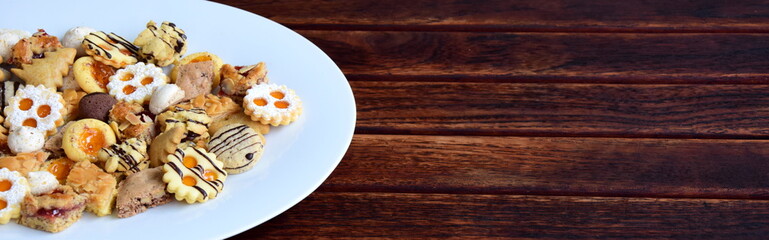 Banner Weihnachten - Weihnachtskekse auf weißen Porzellan und dunklen Holztisch mit Texfreiraum