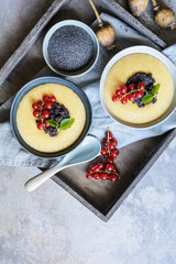 Sweet cornmeal porridge, topped with poppy seeds and currant