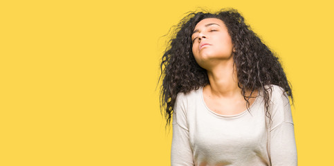 Young beautiful girl with curly hair wearing casual sweater with hand on stomach because indigestion, painful illness feeling unwell. Ache concept.