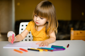 little cute blonde girl drawing at home
