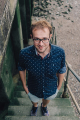 Happy young man in glasses spending time in docklands in London.