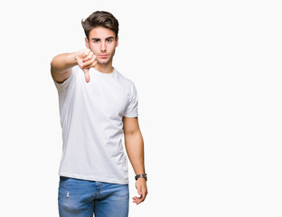 Young handsome man wearing white t-shirt over isolated background looking unhappy and angry showing rejection and negative with thumbs down gesture. Bad expression.