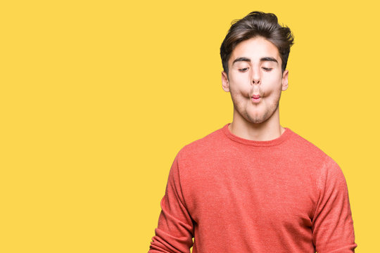 Young handsome man over isolated background making fish face with lips, crazy and comical gesture. Funny expression.