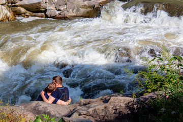 couple in love on the bank of a mountain river