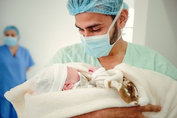 padre mirando bebe recién nacido