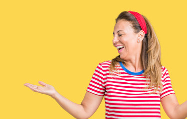 Beautiful middle age woman wearing casual stripes t-shirt over isolated background Smiling showing both hands open palms, presenting and advertising comparison and balance