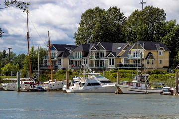 Small Village of new houses  at the riverside of Fraser River, with marina for parking  boats and...