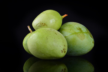 Fresh green mango over black background