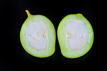 green mango half on black background