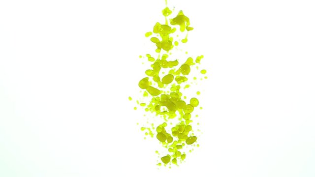 Yellow oil drops in water pouring down then rising back up to the top slow motion