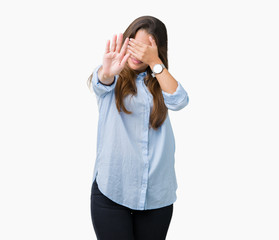 Young beautiful brunette business woman over isolated background covering eyes with hands and doing stop gesture with sad and fear expression. Embarrassed and negative concept.