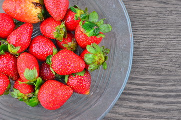 Appetizing strawberry in the bowl on wooden background