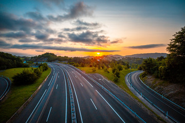 Sunset on a highway, enter the clouds to cover the sun and take an orange color, Basque Country