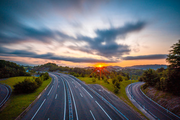 Long exposure in a sunset on a road, enter the clouds to cover the sun and take an orange color. Basque Country