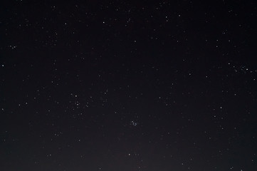 Fototapeta na wymiar Underexposed night sky low light photo. A lot of stars and constellations on dark sky. Stock photo of deep sky.