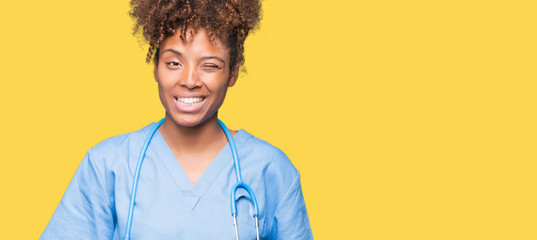 Young african american doctor woman over isolated background winking looking at the camera with...