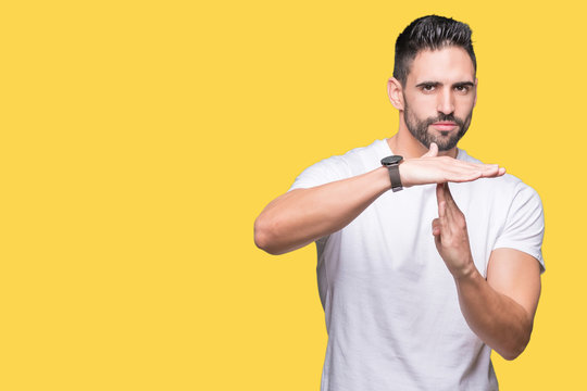Handsome man wearing white t-shirt over yellow isolated background Doing time out gesture with hands, frustrated and serious face