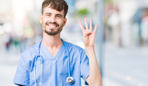 Young handsome nurse man wearing surgeon uniform over isolated background showing and pointing up with fingers number four while smiling confident and happy.