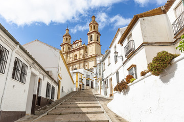 Fototapeta na wymiar a street in Olvera town and Our Lady of the Incarnation church, province of Cadiz, Andalusia, Spain